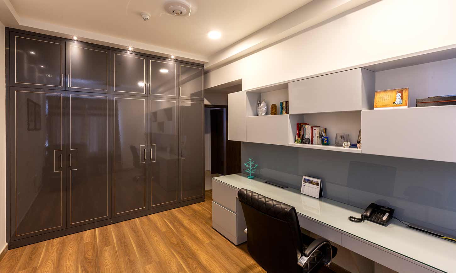 house interior design in bangalore with a grey and white theme for home office with a glossy wardrobe